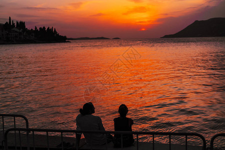 年轻夫妇坐在沙滩上看日落图片
