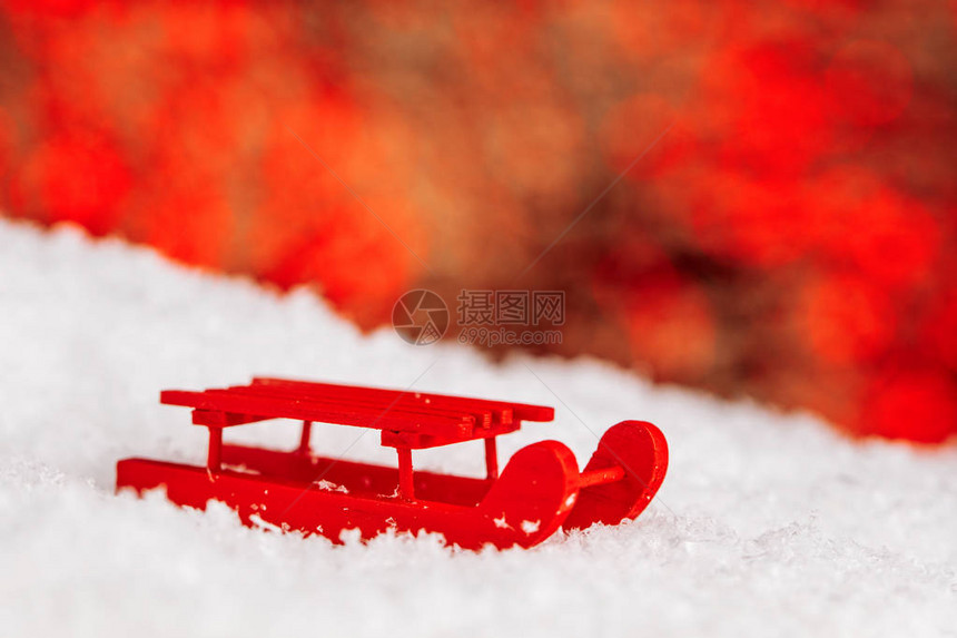 红色雪橇与白色背景上孤立的雪图片