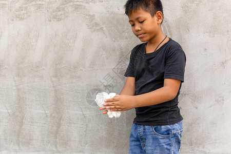 亚洲男孩用湿纸巾擦手背景图片