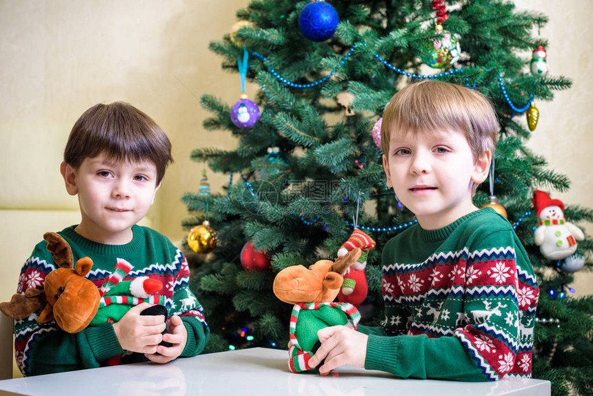 在家或幼儿园玩快乐的男孩在新年树背景游戏与xma图片