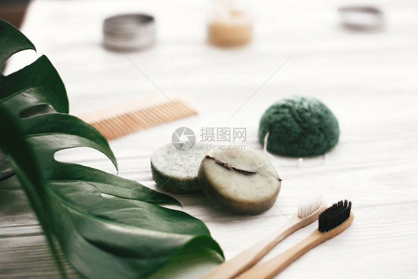 天然竹牙刷洗发水棒玻璃中的牙膏木笔刷和白木底的Konjaku海绵图片