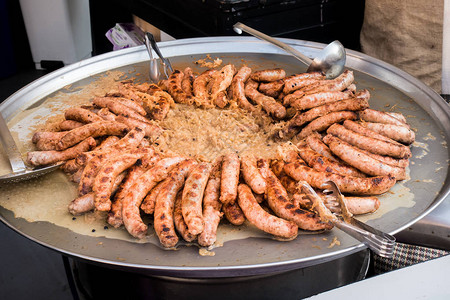 香肠和酸菜在一个大平底锅里煮熟街头食品图片