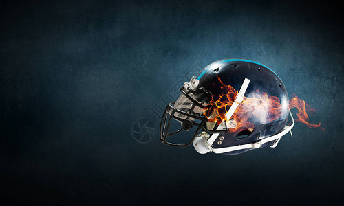 黑暗背景下火焰中的运动头盔背景图片