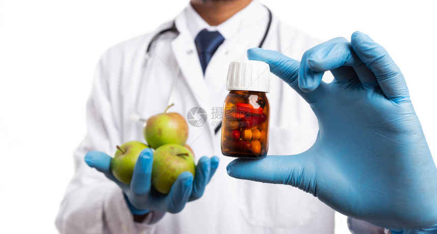 由印度医生医生和苹果持有的饮食药瓶图片