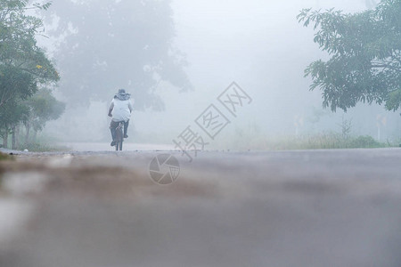 一个孤单的骑自行车者在雾中骑着自行车图片