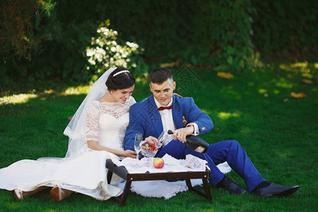 刚结婚的爱时髦夫妇穿着婚纱和西装在公园里幸福的新娘和新郎走在美丽的花园里浪漫的已婚年轻家背景图片