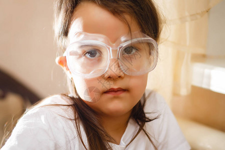 小女孩在初级科学课上用保护眼镜做小女背景图片