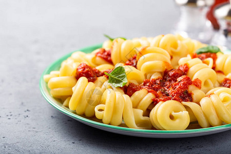 蔬菜意面番茄酱和厨房桌边的烤肉健康的意大利食品概念复制空图片