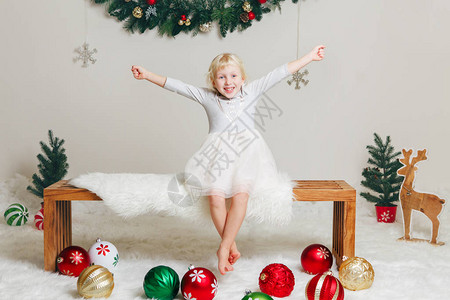 白色种人儿童女孩的肖像穿着优雅的裙子坐在木凳上庆祝圣诞节或新年图片