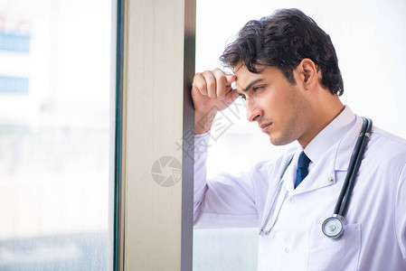 站在窗口的年轻英俊的医生图片