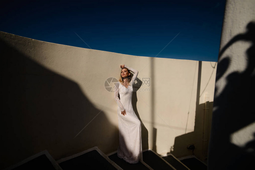 希腊圣托里尼岛穿着白色婚纱的美丽金发美女新娘图片