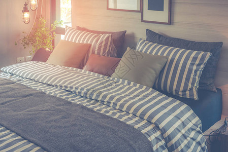 带有一套枕头和床上条纹毯子室内设计装饰概念的现代图片