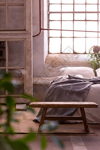 床前的木凳与灰色毯子在工业卧室内部与植物图片