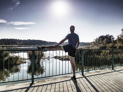 赛跑者在海湾大桥上做伸展运动一个活跃的瘦子站在一条腿图片