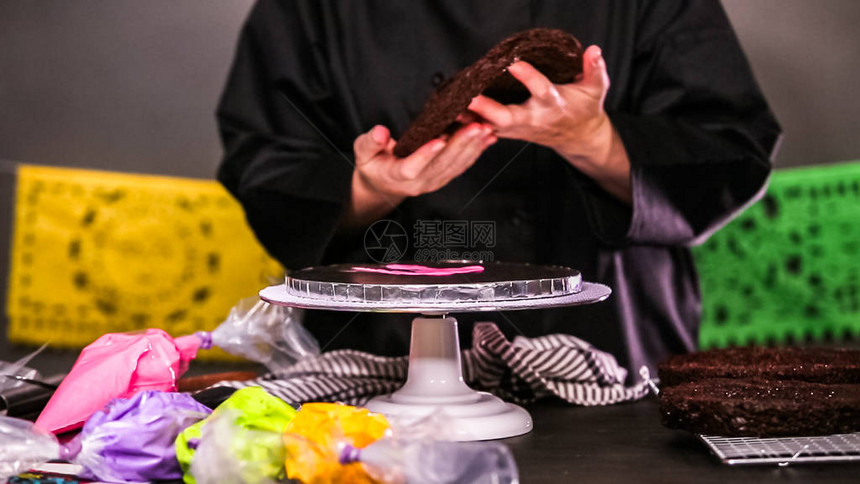 贝克准备一个巧克力蛋糕盛满鲜艳的奶油淇淋糖霜为DiadelosMuert图片