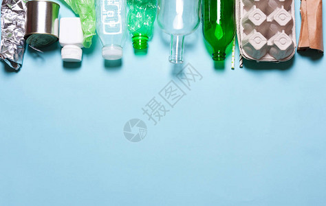 蓝色背景上的家庭垃圾分类塑料聚乙烯纸板纸张玻璃的概念环图片