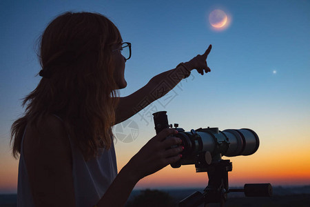 女孩通过望远镜观察月蚀我的天文学工作图片