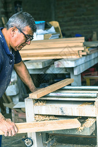 木匠用皮带拖拉机在木材上用皮图片