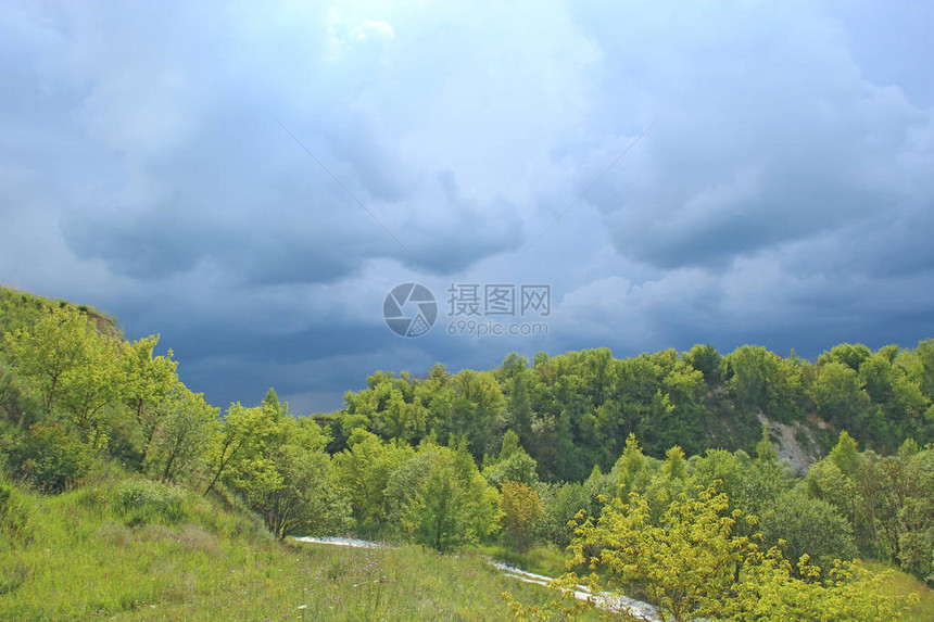 与雷云在绿色森林上空的景观绿色植被上方的风暴云美丽的雨云与深蓝色的云雨前的自然图片