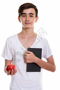 年轻英俊的波斯少年男孩手持书和红苹果图片