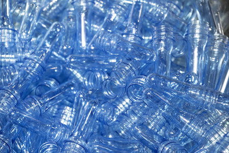 在浅蓝色场景中吹散塑料瓶工艺的PET瓶的预形饮用水容器制造加工图片