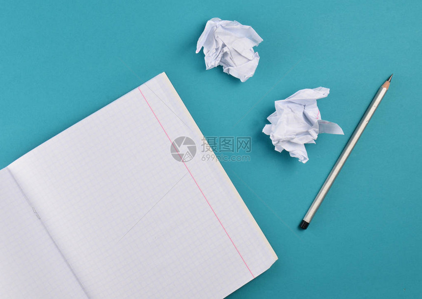 用铅笔和白圆纸球在蓝背景上的笔记本的顶部视图无知教育最图片