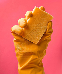 一只手戴黄色橡皮手套用粉红色背图片