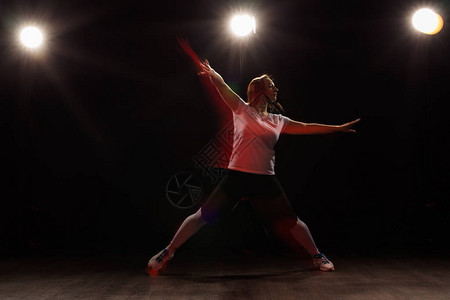跳舞运动美丽和人的概念在黑暗中跳舞的年轻女子在五颜六色图片