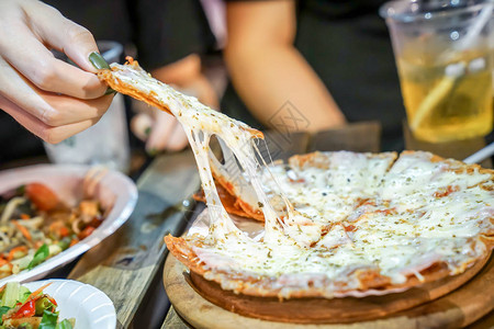 女人的手拿披萨馅饼从比萨盘上拿出来在食品卡车事件图片