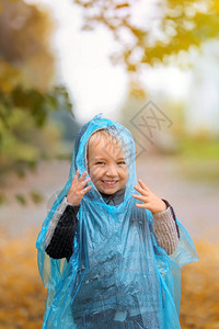 穿雨衣的可爱小男孩在秋天图片