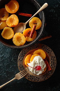 甜点加肉桂奶油和樱桃在黑暗背景上图片