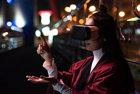 迷人的亚洲女孩使用虚拟现实耳机图片