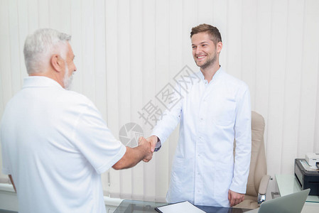 两位英俊的医生在灯柜里握手图片