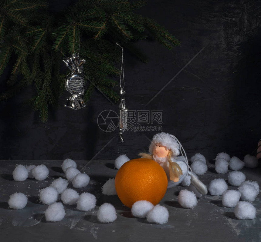 圣诞贺卡玩具拿着桔子的小女孩大块的雪在圣诞树枝图片