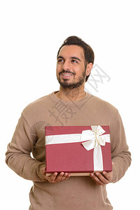 年轻快乐的印度男人拿着礼物盒一边想着图片