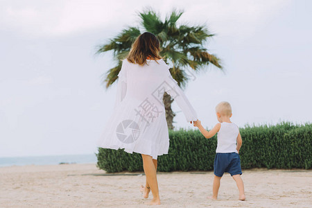 阿联酋迪拜沙滩上的年轻母亲和背景图片
