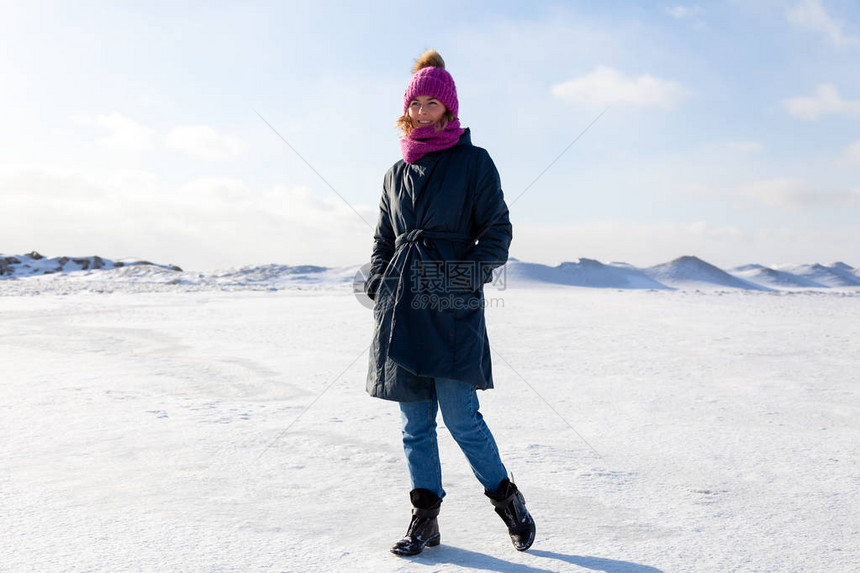 一位戴着粉色针织帽黑色外套的年轻女子享受冬季自然图片