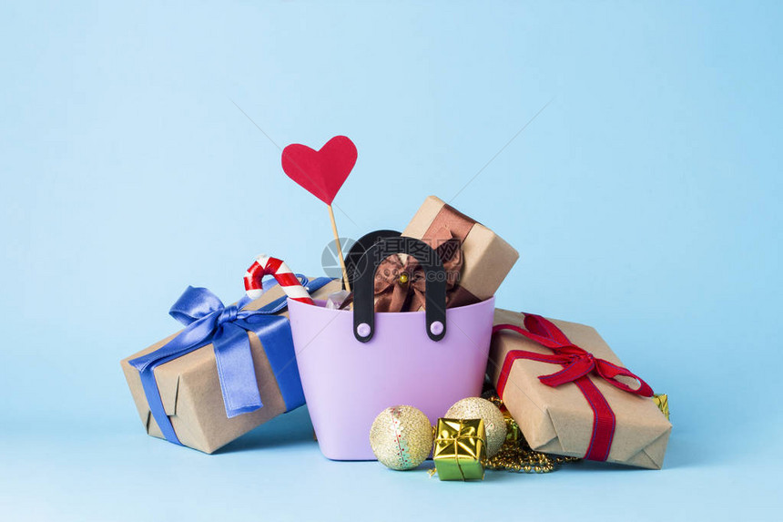 用于购物的小塑料袋礼品盒棍子上的心蓝色背景图片