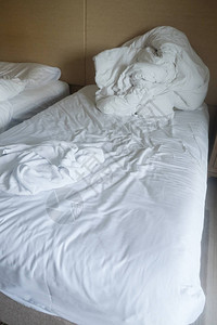 长夜睡醒后早上醒来时在卧室里用毛毯和白枕头擦皱乱的毯图片