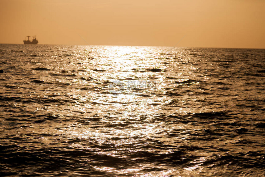 有海浪的海和有船的日落天空图片