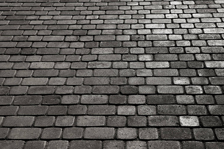 铺有斑岩立方体的城市卵石的质地一条街道的地板与石瓦片花岗岩图片