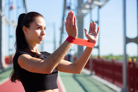 有吸引力的体育运动女在桥上用橡胶抗力带进行训练图片