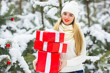 快乐的年轻女子拿着装有圣诞礼物的盒子户外有红图片