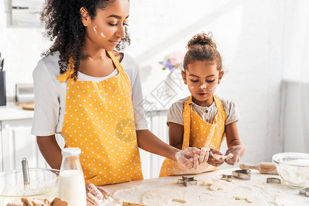 非洲自信的美国母亲和女儿在厨房用模具做图片