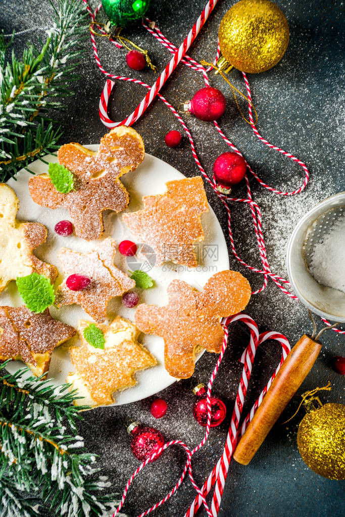 圣诞早餐的创意姜饼人圣诞树和星形式的有趣圣诞煎饼带圣诞装饰的深色混凝土图片