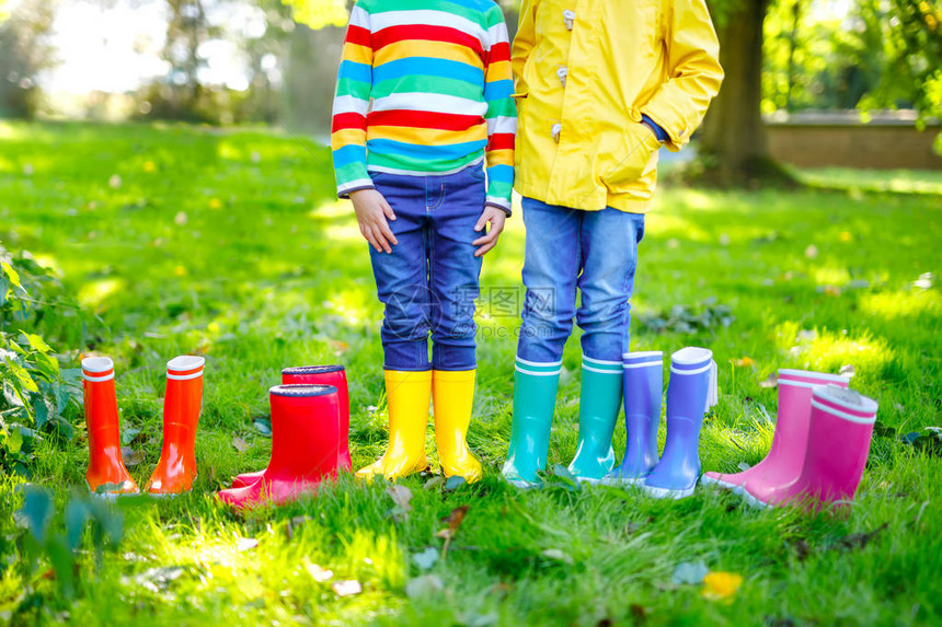 小孩子男孩和女孩穿着五颜六色的雨靴穿着不同橡胶靴牛仔裤和夹克的儿童的特写镜图片