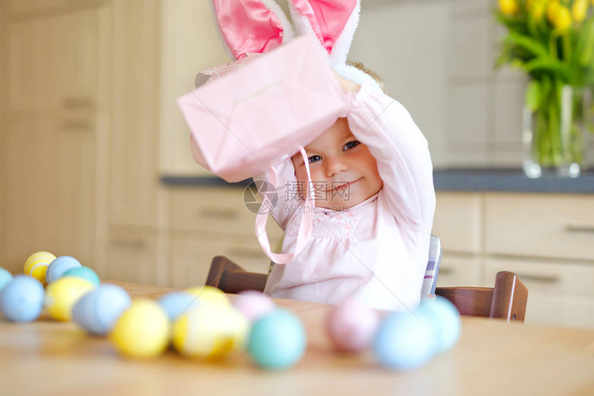 可爱的蹒跚学步的小女孩戴着复活节兔子耳朵玩彩色粉彩蛋快乐的宝贝孩子打开礼物穿着粉红色衣服的可爱健康微笑孩子享图片