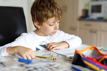 早上开学前在家做作业的疲倦小男孩小孩在室内做运动图片