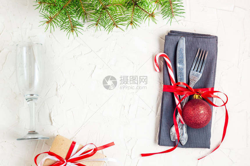 与树冷杉树枝餐巾叉子刀子球糖果手杖礼物和玻璃的圣诞节桌餐位具圣诞假期背景平躺图片