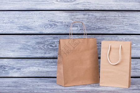 用木制背景的棕色纸购物袋背景图片